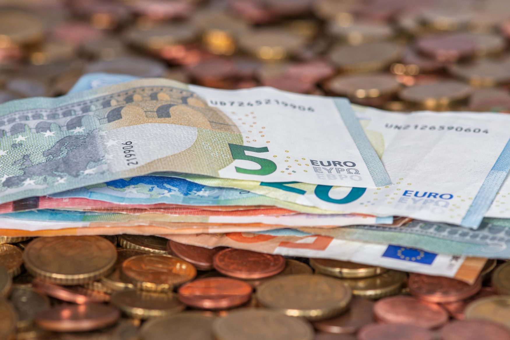 Euro banknotai ir monetos, simbolizuojantys pinigus ir paskolos galimybes sudėtingesnėje finansinėje situacijoje.