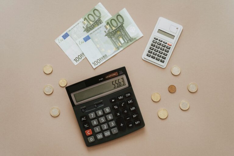 Eurų banknotai, monetos ir skaičiuotuvai, simbolizuojantys finansų valdymą, įmokų perskaičiavimą ir taupymą.